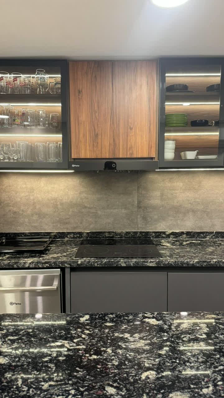 Cocina con alacenas de vidrio y mesada de granito